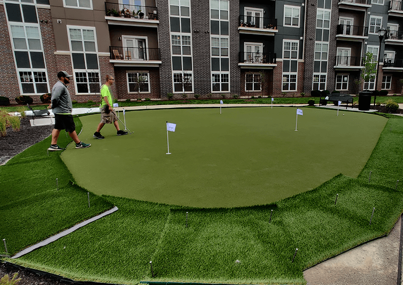 synlawn putting green outside apartment residence