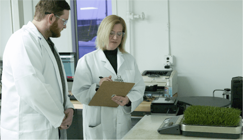 image of two scientist testing the quality of SYNLawn turf