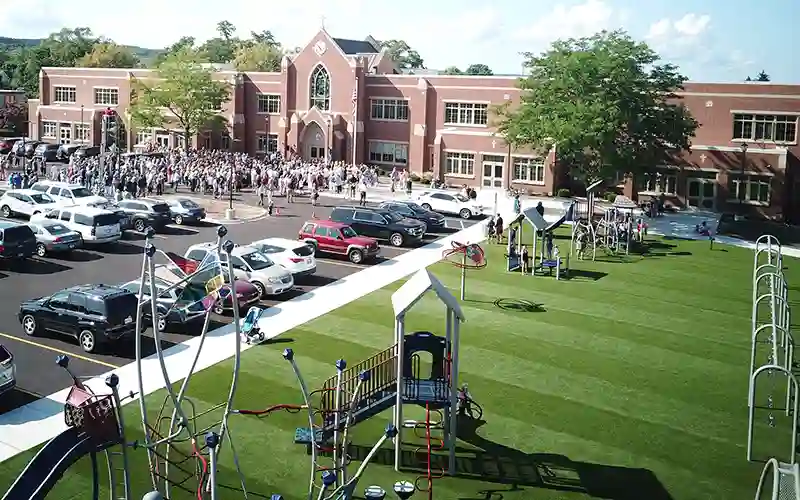 SYNLawn artificial grass with a playground near a parking lot with a large group of people celebrating