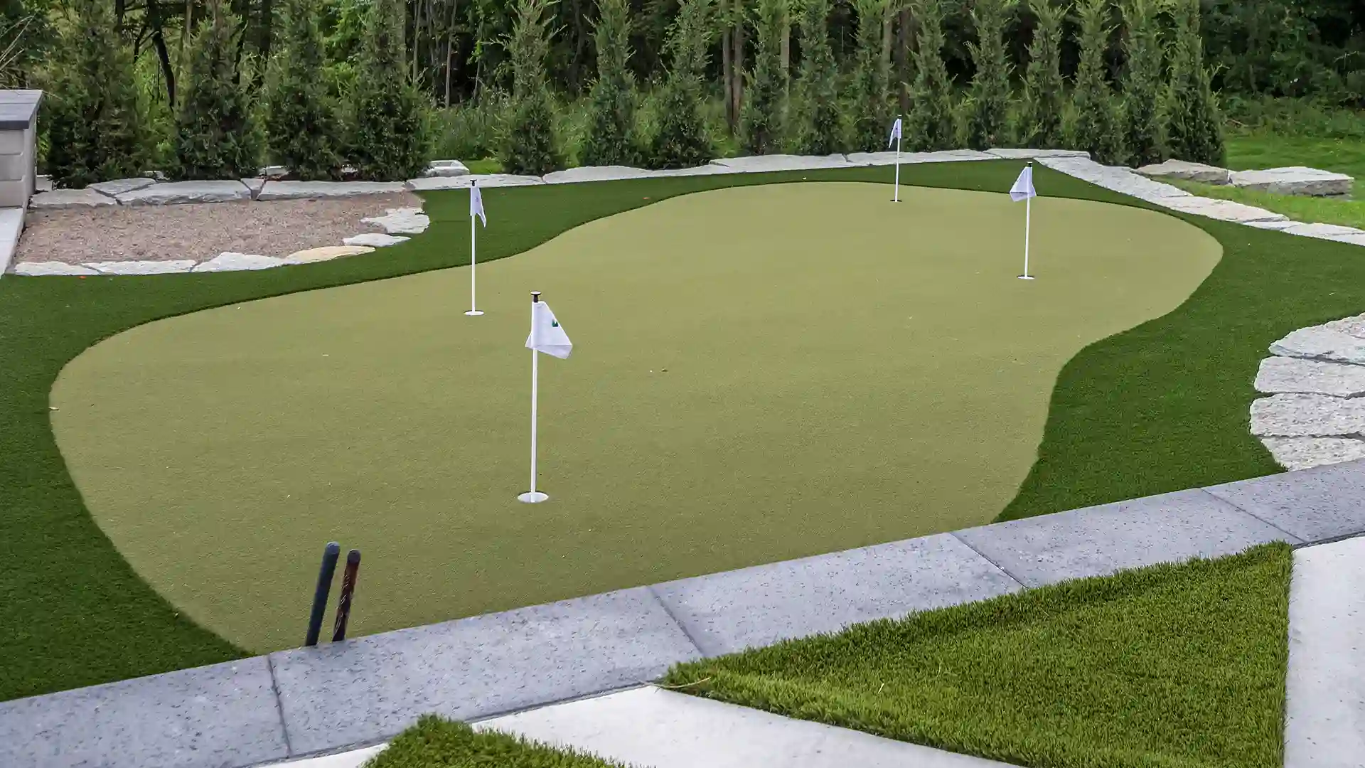 image of SYNLawn artificial grass landscape backyard design with custom putting green and paver design at upscale luxury home in Rochester Hills Michigan